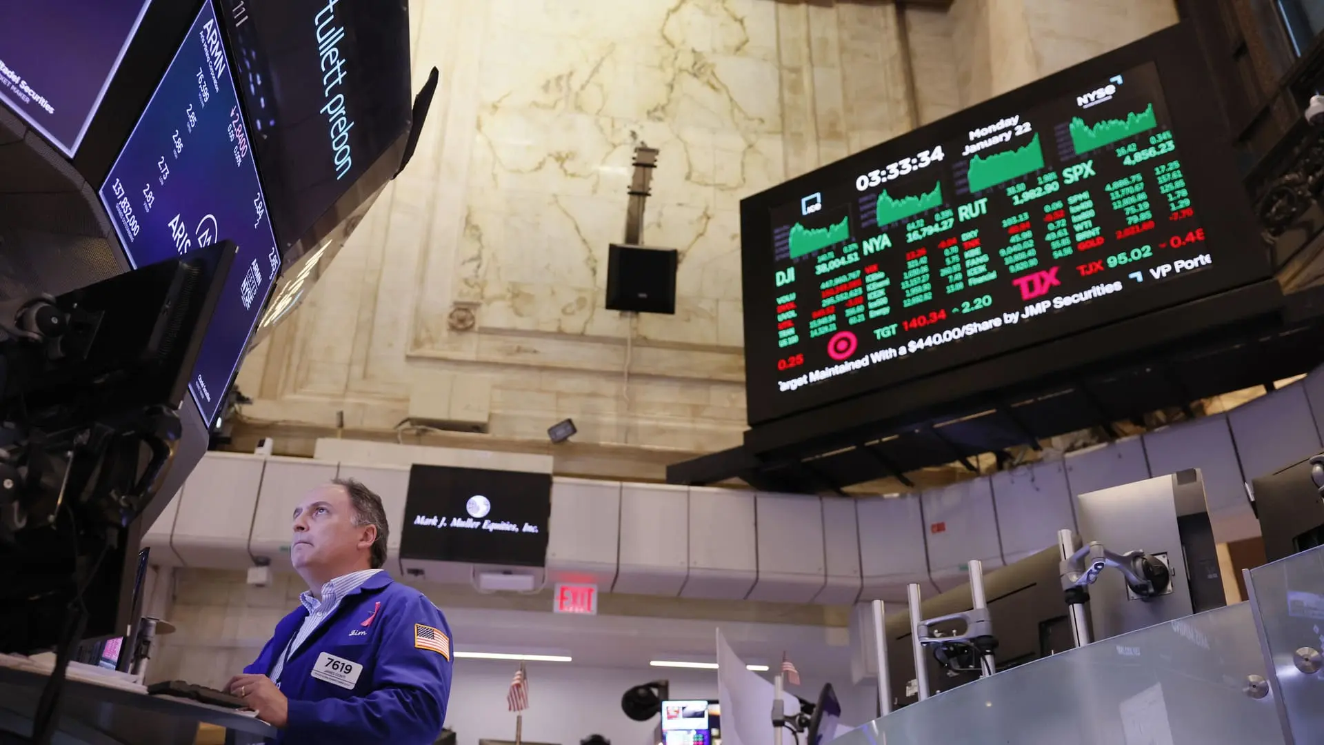 Stock trader standing at desk in the New York Stock Exchange.