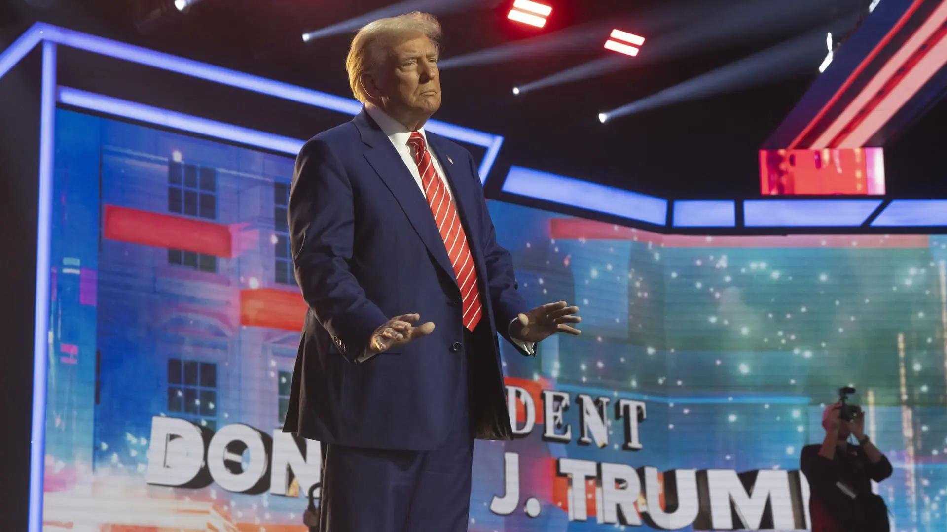 Donald Trump on stage surrounded by bright lights.